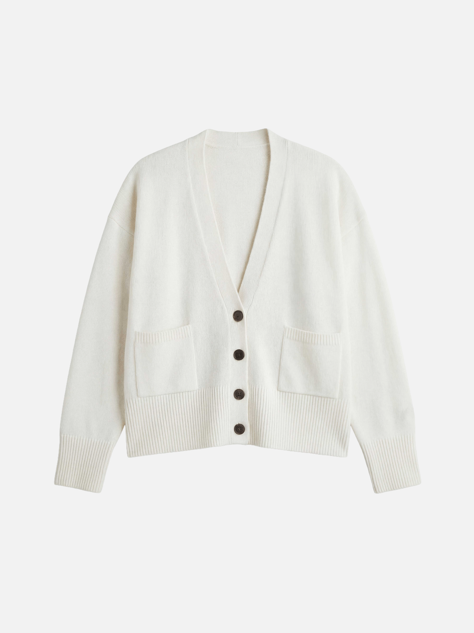 White cardigan with black buttons on a light gray background