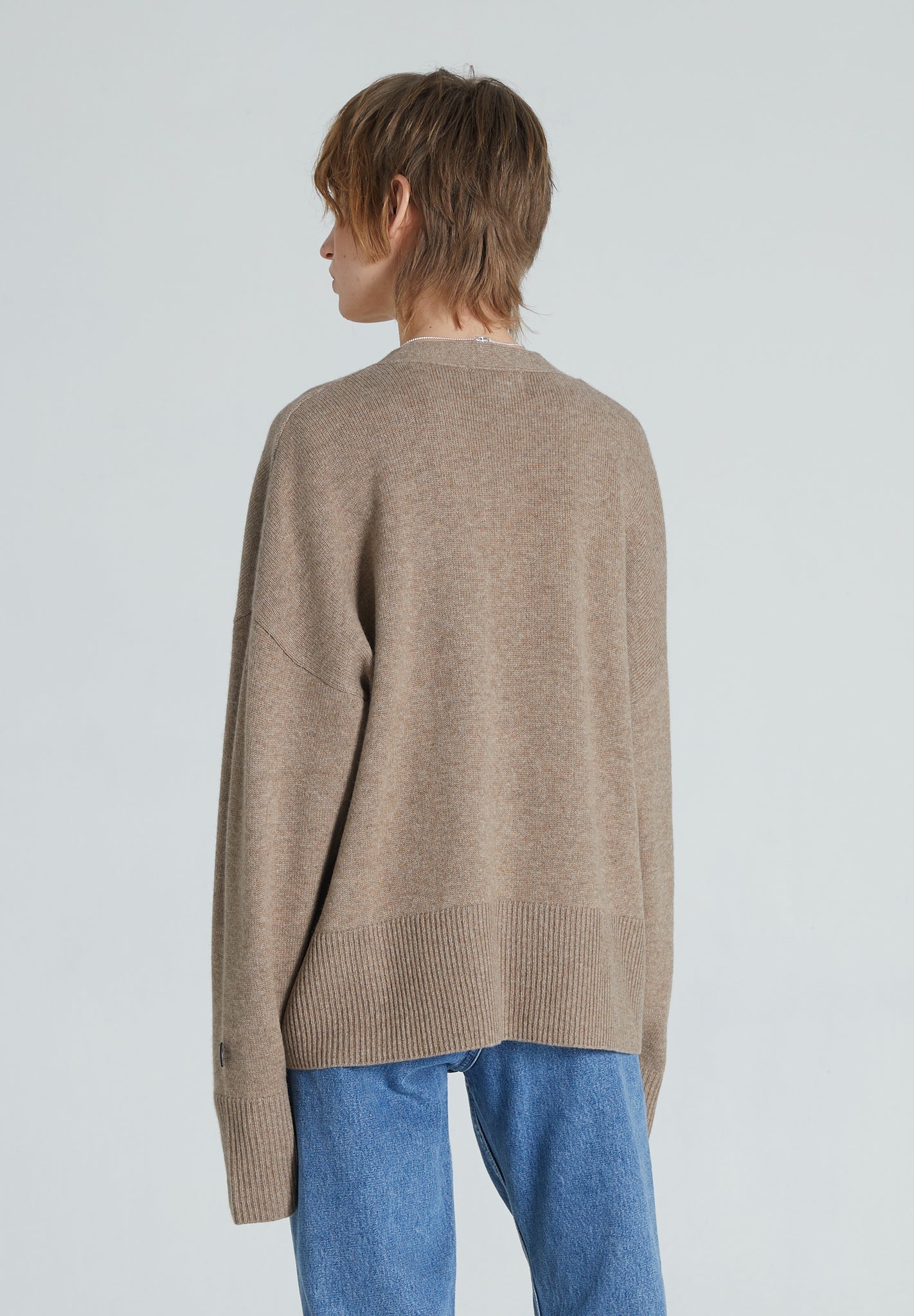 Back of a brown cashmere cardigan with long sleeves and relaxed fit. 