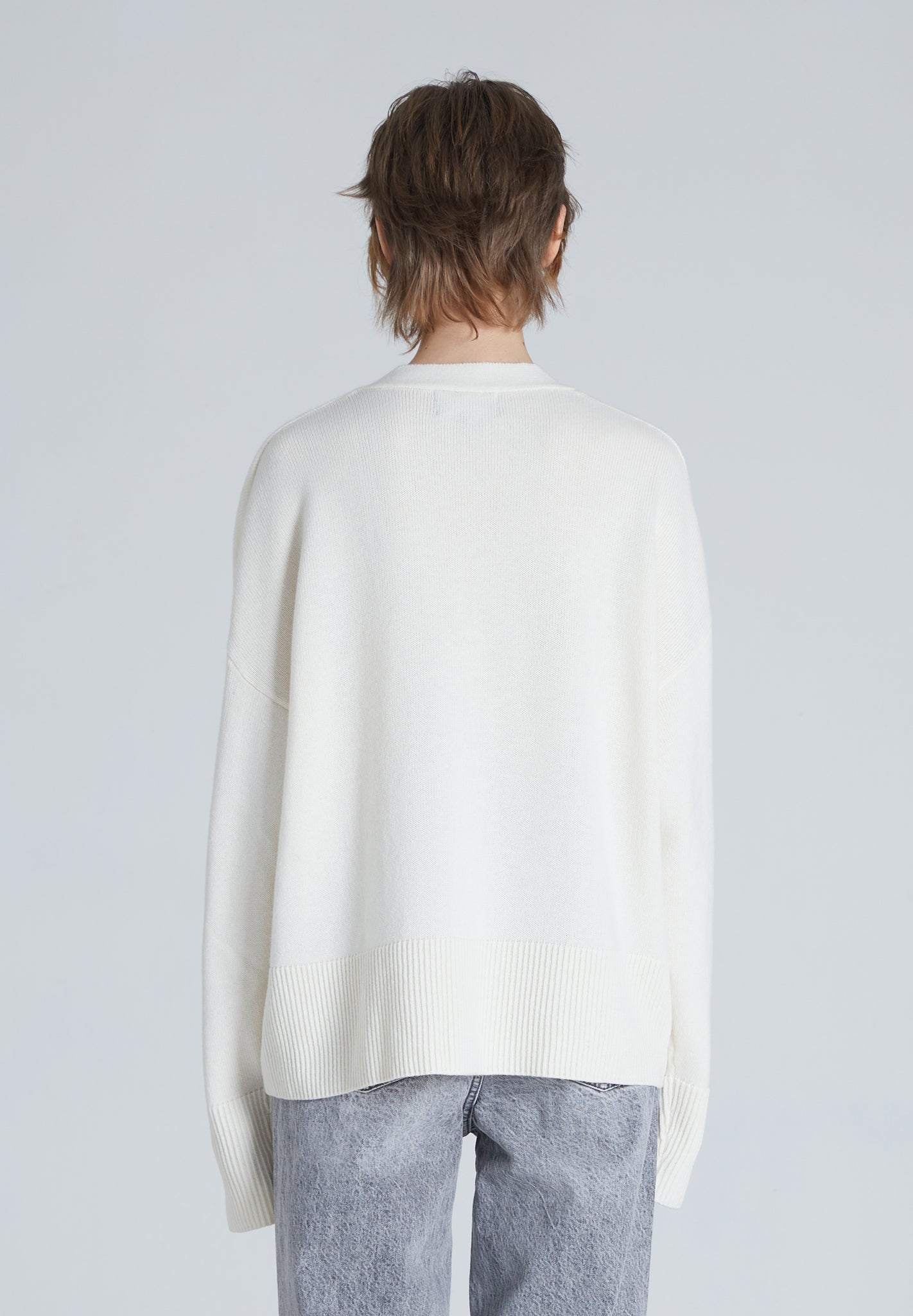The back of a Cream colored cashmere cardigan with relaxed fit and certified craftsmanship.