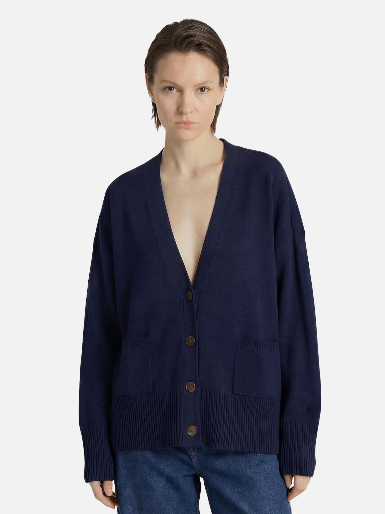Person wearing a navy blue cardigan on a white background
